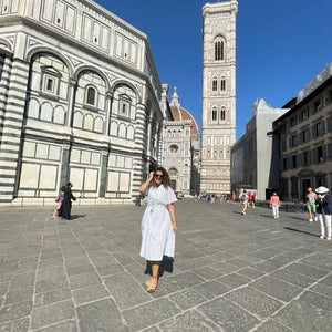 Social media shot featuring the Yara midi belted dress in white. Shot in Italy, styled with wedges and black sunglasses.